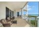 Inviting balcony space with comfortable wicker chairs, offering serene bay views and plenty of sunlight at 2050 Benjamin Franklin Dr # A1001, Sarasota, FL 34236