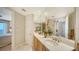 Charming bathroom with double sinks, marble countertop, large mirror and entry to bedroom at 2050 Benjamin Franklin Dr # A1001, Sarasota, FL 34236