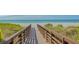 Picturesque beach access featuring a wooden boardwalk leading to soft sand and the ocean at 2050 Benjamin Franklin Dr # A1001, Sarasota, FL 34236