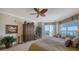 A tastefully decorated bedroom featuring a balcony with water views and dark-stained armoire at 2050 Benjamin Franklin Dr # A1001, Sarasota, FL 34236