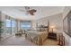 A beautifully furnished primary bedroom with a water view and a decorative ceiling fan at 2050 Benjamin Franklin Dr # A1001, Sarasota, FL 34236