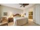 A cozy bedroom with a ceiling fan, comfortable chair, and glimpse into ensuite bathroom at 2050 Benjamin Franklin Dr # A1001, Sarasota, FL 34236