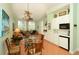 Open dining area with glass table, seating, and adjacent kitchenette with white cabinets at 2050 Benjamin Franklin Dr # A1001, Sarasota, FL 34236