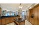 Open kitchen layout boasting wooden cabinetry, granite countertops, a center island, and stainless steel appliances at 2050 Benjamin Franklin Dr # A1001, Sarasota, FL 34236