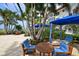 Comfortable outdoor lounge area with blue cushioned chairs and umbrellas near the beach at 2050 Benjamin Franklin Dr # A1001, Sarasota, FL 34236