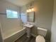 A renovated bathroom with white tiled walls, a pedestal sink and modern fixtures at 21114 Gladis Ave, Port Charlotte, FL 33952