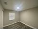 A bright bedroom featuring grey wood flooring, fresh neutral paint, and modern lighting at 21114 Gladis Ave, Port Charlotte, FL 33952