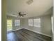 Bedroom with gray floors, ceiling fan, fresh paint, sun-filled windows, and an exterior door at 21114 Gladis Ave, Port Charlotte, FL 33952