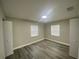 A modern bedroom with neutral paint, grey wood floor and two windows at 21114 Gladis Ave, Port Charlotte, FL 33952