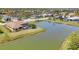 Waterfront home featuring an enclosed pool, lush lawn, and mature palm trees at 2281 Vintage St, Sarasota, FL 34240