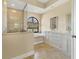 Bright bathroom boasts a soaking tub under an arched window and a separate glass-enclosed shower at 2281 Vintage St, Sarasota, FL 34240