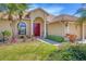 Charming single-story home with lush landscaping, a vibrant red front door, and a spacious two-car driveway at 2281 Vintage St, Sarasota, FL 34240