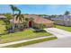 Charming single-story home with lush landscaping, a vibrant red front door, and a spacious two-car driveway at 2281 Vintage St, Sarasota, FL 34240