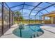 Screened-in pool features a spa, waterfall, and view of the lush backyard and lake at 2281 Vintage St, Sarasota, FL 34240
