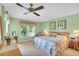 Inviting bedroom with light green walls, a ceiling fan, and floral bedding at 235 Rotonda W Blvd # C102, Rotonda West, FL 33947