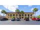 Condo building with arched entryways and palm trees in front of ample parking at 235 Rotonda W Blvd # C102, Rotonda West, FL 33947