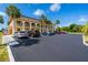 Condo building with palm trees and ample parking at 235 Rotonda W Blvd # C102, Rotonda West, FL 33947