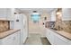 Bright kitchen features white cabinets, granite counters and tile backsplash at 235 Rotonda W Blvd # C102, Rotonda West, FL 33947