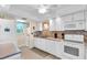 Kitchen featuring white appliances and adjacent laundry at 235 Rotonda W Blvd # C102, Rotonda West, FL 33947