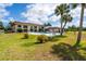 Community pool with palms trees and a fenced in pool deck surrounded by green grass at 235 Rotonda W Blvd # C102, Rotonda West, FL 33947