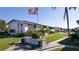 Well-maintained condos with lush landscaping, sign, and American flag on a clear day at 2505 Beneva Rd # 3, Sarasota, FL 34232
