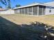 View of a spacious screened lanai and backyard featuring lawn in need of care in a sunny real estate setting at 3608 67Th Street Ct W, Bradenton, FL 34209