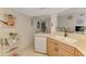 Bright kitchen featuring light wood cabinets, white appliances, and decorative artwork at 4091 Center Pointe Pl # 40A, Sarasota, FL 34233