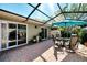 Outdoor patio area featuring brick pavers, screened enclosure, dining set, and sliding glass doors to house at 4091 Center Pointe Pl # 40A, Sarasota, FL 34233