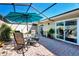 Outdoor patio area featuring brick pavers, a screened enclosure, and a dining set with umbrella at 4091 Center Pointe Pl # 40A, Sarasota, FL 34233