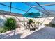 Outdoor patio area with brick pavers, a screened enclosure, and a dining set under an umbrella at 4091 Center Pointe Pl # 40A, Sarasota, FL 34233