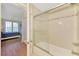 Bathroom with tiled shower, glass doors, and adjacent bedroom access at 4118 Central Sarasota Pkwy # 1636, Sarasota, FL 34238