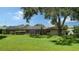 Green backyard with mature trees and screened in pool at 4848 Greywood Ln, Sarasota, FL 34235