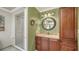 Bathroom featuring a granite vanity, a round mirror, and a tiled walk-in shower at 4848 Greywood Ln, Sarasota, FL 34235