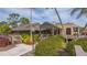 Inviting clubhouse entrance with lush landscaping, well-maintained walkways, and beautiful architectural details in the community at 4848 Greywood Ln, Sarasota, FL 34235