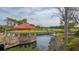 Charming patio area with red canopy, providing scenic golf course views and a relaxing space for members and guests in community at 4848 Greywood Ln, Sarasota, FL 34235