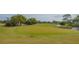 Expansive golf course view highlighting manicured greens, water features, and the natural beauty of the golf community, under blue sky at 4848 Greywood Ln, Sarasota, FL 34235