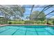 Screened-in pool overlooking a lush green golf course with a clear blue sky at 4848 Greywood Ln, Sarasota, FL 34235