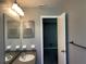 Bathroom featuring a sink, mirror, medicine cabinet, and lighting. A doorway leads to the adjacent room at 5013 Village Gardens Dr # 34, Sarasota, FL 34234