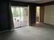 Bedroom with neutral carpet, access to a bathroom, and a sliding glass door to the exterior at 5013 Village Gardens Dr # 34, Sarasota, FL 34234