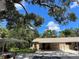 Single-story home featuring a covered parking area and surrounded by mature trees at 5013 Village Gardens Dr # 34, Sarasota, FL 34234