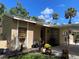 Beautifully landscaped home exterior featuring potted plants and manicured lawn under a sunny sky at 5013 Village Gardens Dr # 34, Sarasota, FL 34234