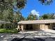 Single-story home featuring a covered parking area and lush landscaping at 5013 Village Gardens Dr # 34, Sarasota, FL 34234