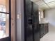 An interior view showcasing kitchen appliances, including a refrigerator and dishwasher, set against a tiled floor at 5013 Village Gardens Dr # 34, Sarasota, FL 34234