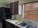 Bright kitchen view featuring a stainless steel sink, dishwasher, and a window with venetian blinds at 5013 Village Gardens Dr # 34, Sarasota, FL 34234