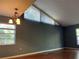 Bright living room featuring a high ceiling, neutral walls, and wood-look flooring, illuminated by windows at 5013 Village Gardens Dr # 34, Sarasota, FL 34234