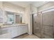 Bright bathroom featuring a double sink vanity with granite countertop, a glass-enclosed shower, and neutral tile flooring at 507 W Cashew, Punta Gorda, FL 33955