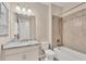 Neutral bathroom features a granite vanity, framed mirror, and tiled shower and tub at 507 W Cashew, Punta Gorda, FL 33955