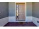 Close-up of a charming front door with a side window and 'wipe your paws' welcome mat at 507 W Cashew, Punta Gorda, FL 33955