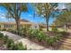 Charming clubhouse with beautiful landscaping and an American flag, under a clear blue sky at 5275 Willow Links # 50, Sarasota, FL 34235