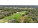 An aerial view shows the lush greenery of a beautiful golf course surrounded by dense trees at 5275 Willow Links # 50, Sarasota, FL 34235